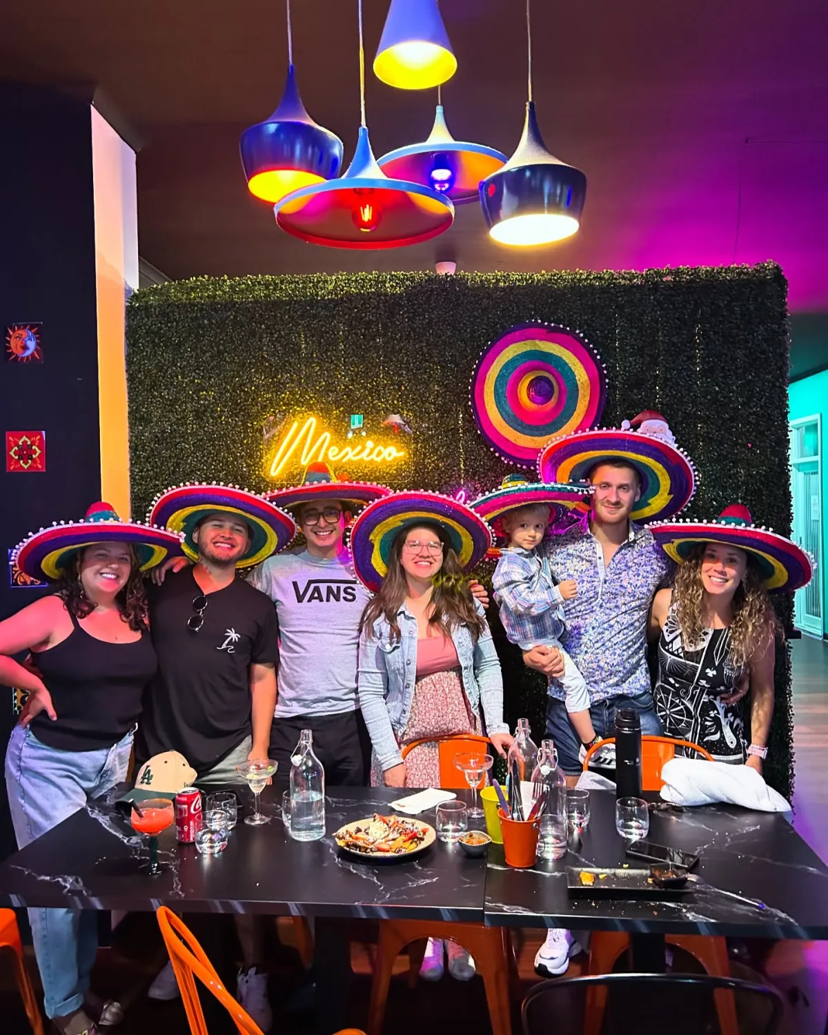Group celebration under neon lights at El Mexicano